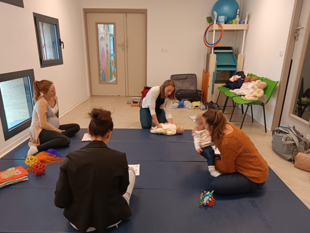 Flore Gheno-Peyre, accompagnante en périnatalité à Sorgues, animant un atelier de portage collectif, démontrant une position sécuritaire et confortable pour les bébés.