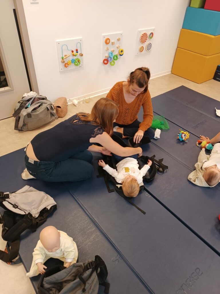 Flore Gheno-Peyre, accompagnante en périnatalité à Sorgues, illustrant la position optimale de portage avec une maman et son bébé lors d'un atelier de portage bienveillant.